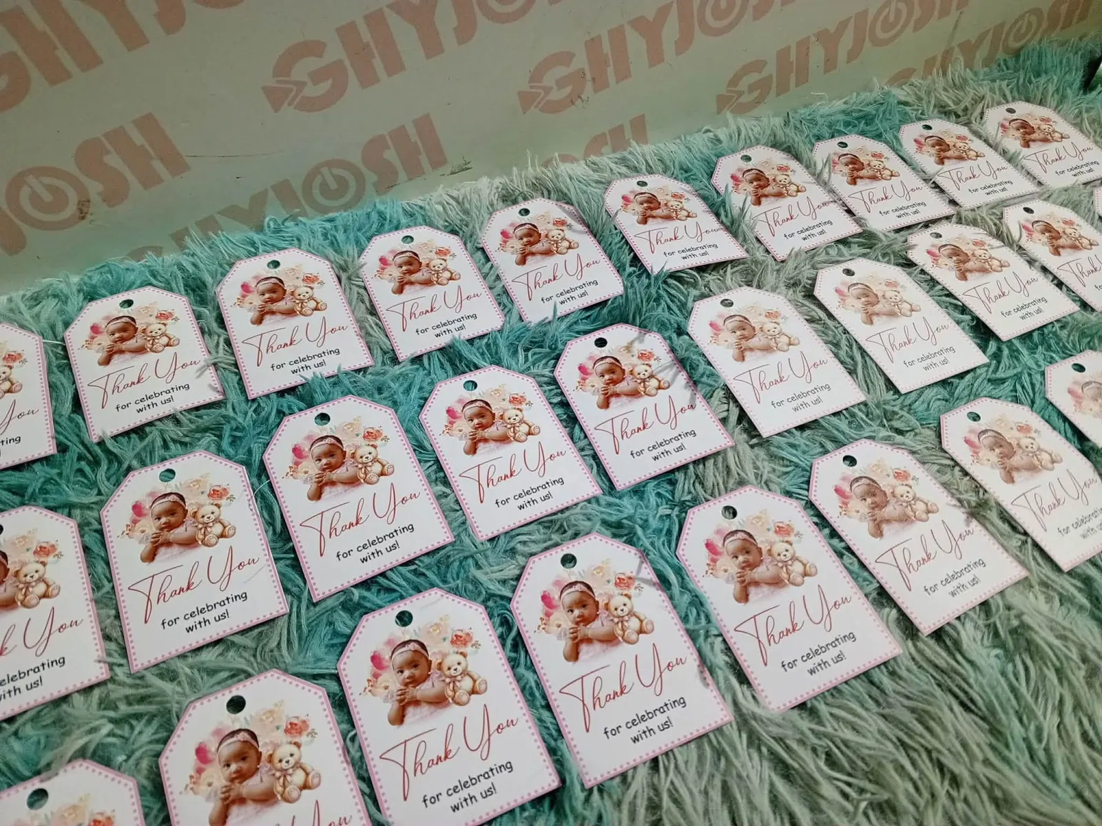 Rows of printed thank-you tags laid out on a blue cloth